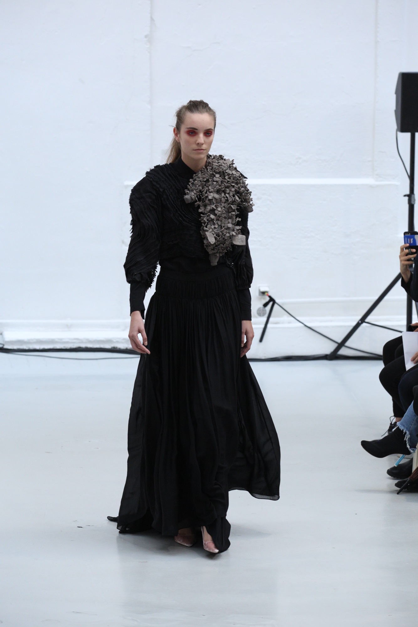 Model in a black pleated couture look