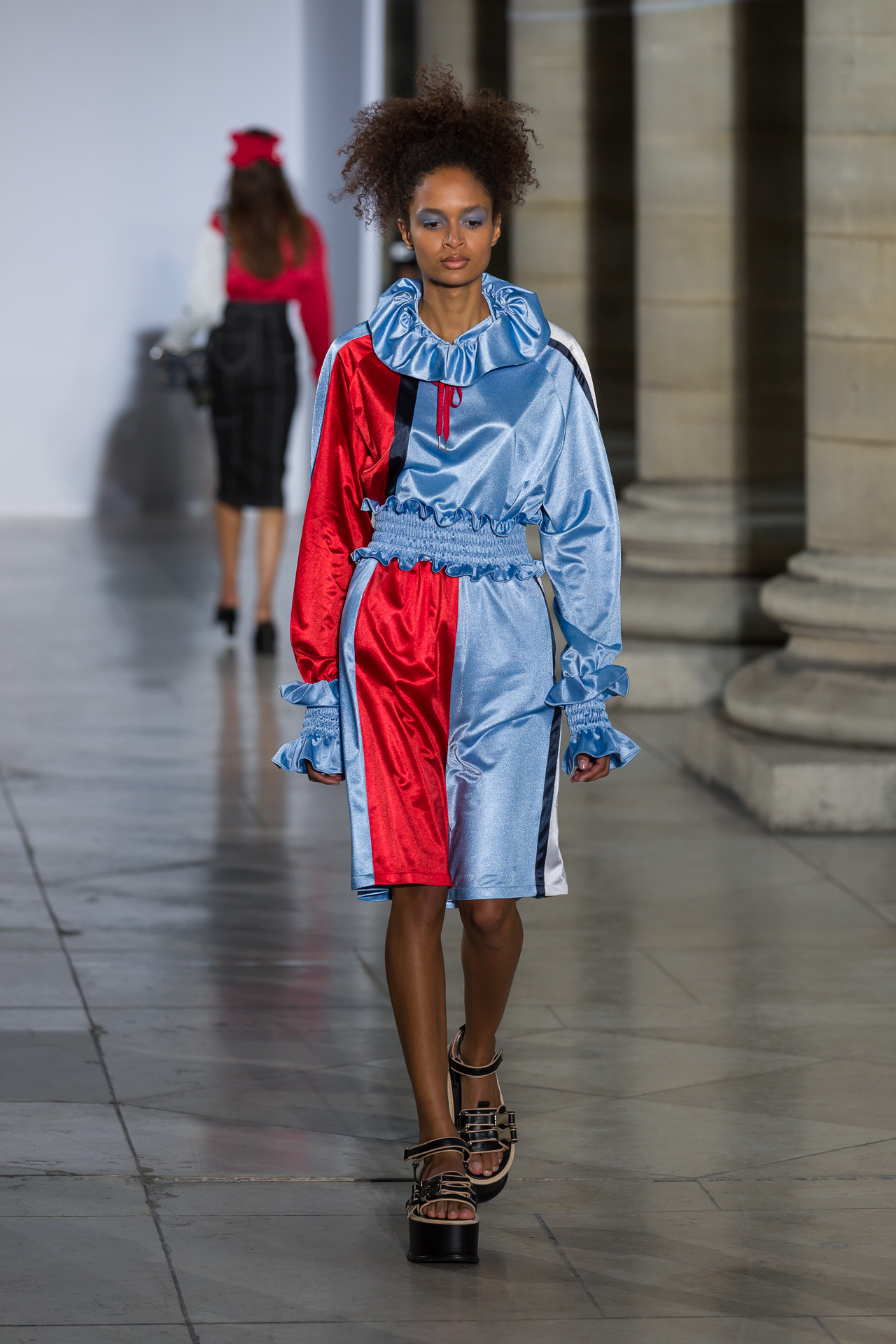 Model in a red-and-blue satin runway look
