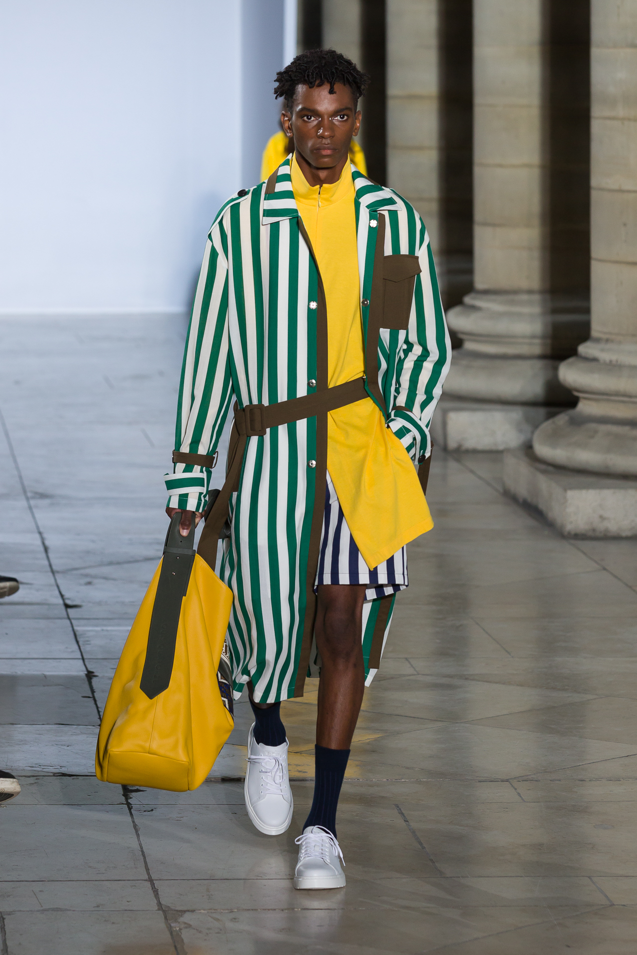 Model in a green striped coat and yellow outfit