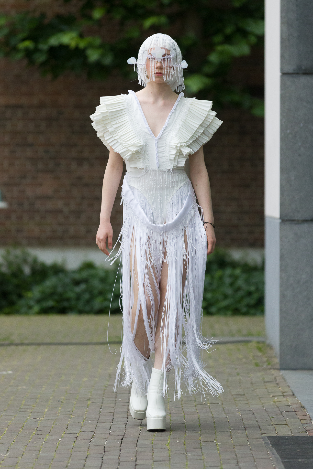 Model in a sculptural white fringed runway look
